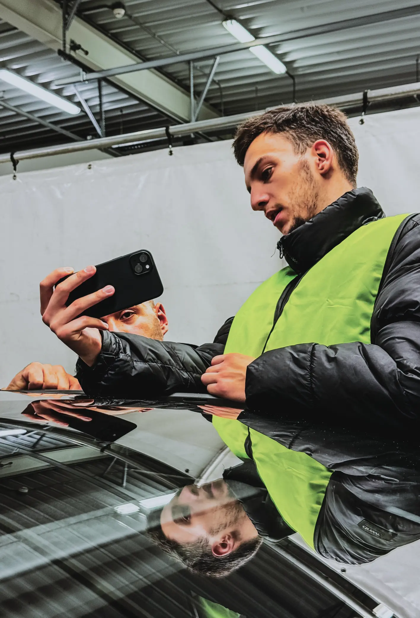 man showing his phone to someone - weR1 automotive